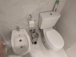 baño blanco con aseo y urinario en Apart 4 Cid Campeador en Buenos Aires