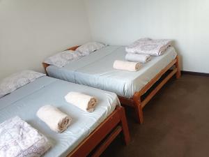 2 łóżka pojedyncze z ręcznikami w pokoju w obiekcie CASA CON COCHERA CERCA A LA PLAYA PlMENTEL w mieście Chiclayo