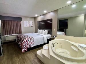 RichlandにあるRed Roof Inn & Suites Richlandのベッドとバスタブ付きのホテルルームです。