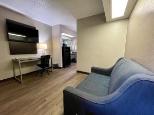 een woonkamer met een bank en een flatscreen-tv bij Red Roof Inn & Suites Richland in Richland