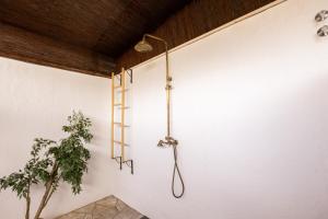 a shower in a white wall with a potted plant at Gce Hoteles in Cártama