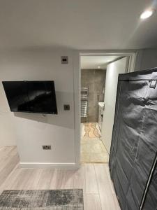 uma sala de estar com uma televisão de ecrã plano na parede em Unique, Stylish, Non-smoking, Riverview Loft EnSuite for Rent em Erith