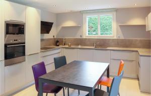 a kitchen with a table and chairs in it at 3 Bedroom Awesome Home In Puy-saint-martin in Puy-Saint-Martin