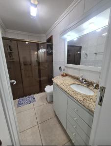 a bathroom with a shower and a sink and a toilet at Apartamento Beira mar Capão da Canoa in Capão da Canoa