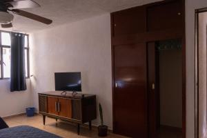- un salon avec une télévision dans un meuble dans l'établissement Estancia Mixtecas, à León