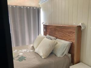 1 dormitorio con cama con cabecero de madera y almohadas en Windsurfer Resort, en Gold Coast