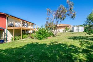 a house with a large yard in front of it at Banksia Waters in Lakes Entrance