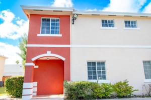 a red and white house with a red door at Good Vibes Oasis - Cozy townhome with parking in Cutler Bay