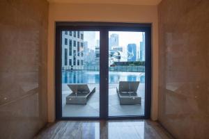 a large glass door with two chairs in a building at Penthouse at Poblacion - 200Mbs net - Awesome view in Manila