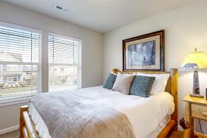 a bedroom with a bed with a lamp and a window at Around the Bend in Bend
