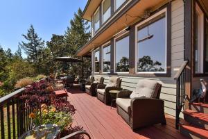 a deck with chairs and tables on a house at Arbutus Hill in Victoria