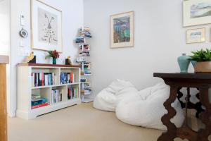 サンシャインビーチにある2 Horizon Terraces - Spacious Duplex Close to Village and Beachの白い本棚と白いビーンバッグチェアのある部屋