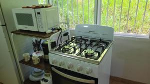 a kitchen with a stove and a microwave at Acogedor apartamento in San Miguelito