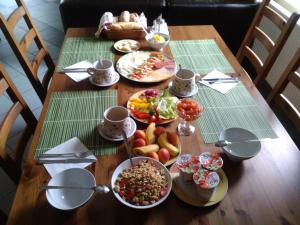 una mesa de madera con platos de comida. en Penzion Eden Turnov en Turnov