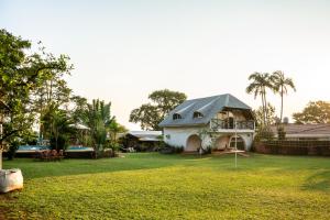 una casa blanca con techo gris en un patio en " Casa quinta "San Bernardo" Con Pileta y amplio jardín en Posadas
