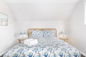 a bedroom with a blue and white bed with two lamps at Sandy Feet Retreat in Geographe