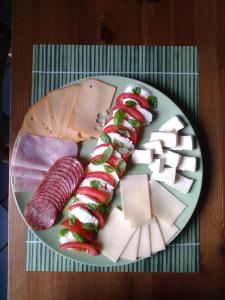 talerz jedzenia z serem i mięsem na stole w obiekcie Penzion Eden Turnov w mieście Turnov