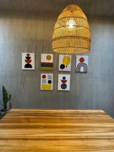 Moderno Loft Santa Ana Costa Rica في سانتا آنا: متدلية على طاولة مع الفن على الحائط
