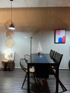 Moderno Loft Santa Ana Costa Rica في سانتا آنا: غرفة طعام مع طاولة سوداء وكراسي