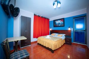 sypialnia z łóżkiem i czerwoną zasłoną w obiekcie Hotel Mayros w mieście Satipo