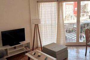Una sala de estar con un televisor de pantalla plana y una mesa. en Torre Libertador I, en Buenos Aires