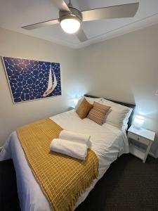 a bedroom with a bed with two towels on it at Central Evans Wagga Apartments in Wagga Wagga