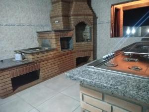 cocina con horno de ladrillo y encimera en Chácara monte tabor en Poços de Caldas