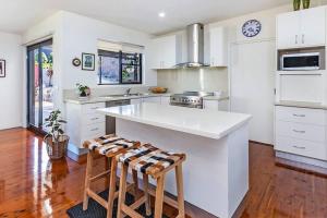 cocina con armarios blancos y encimera blanca en Spacious, light-filled retreat, en Warrnambool