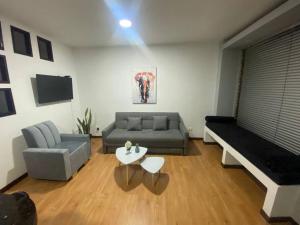 ein Wohnzimmer mit einem Sofa und einem Tisch in der Unterkunft Espectacular,Moderno y como apto, hasta 6 personas in Hojas Anchas