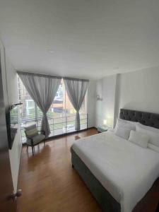 ein Schlafzimmer mit einem großen Bett und einem großen Fenster in der Unterkunft Espectacular,Moderno y como apto, hasta 6 personas in Hojas Anchas