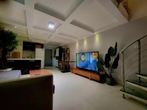 Una televisión o centro de entretenimiento en Chaoyang Joy City Hardcover Apartment