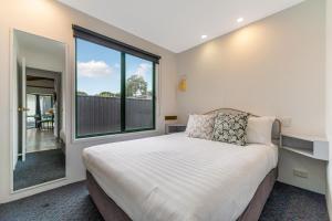 a bedroom with a bed and a large window at Tasman Holiday Parks - Geelong in Geelong