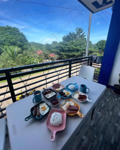 uma mesa com pratos de comida numa varanda em Charlotte's Vacation Home Busuanga Palawan 