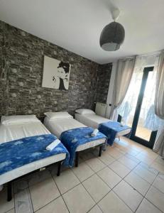 um quarto com 2 camas e uma parede de tijolos em Affittacamere House em Rho