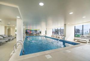 a swimming pool in a building with chairs at Deko Apartments Alezzi Beach Mamaia in Mamaia Nord