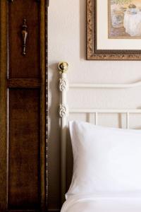 1 cama con almohada blanca y una foto en la pared en The Bishop Hotel, en Port Townsend