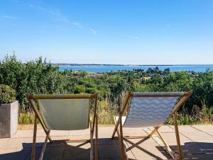 Dos sillas sentadas en un patio con vistas al océano en 8 person holiday home in Ebeltoft en Ebeltoft