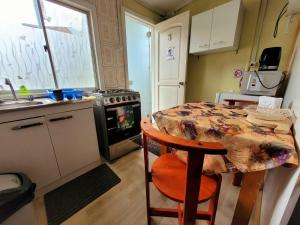 cocina pequeña con mesa y fogones en Hospedaje los Alamos, en Osorno 8 fotos más