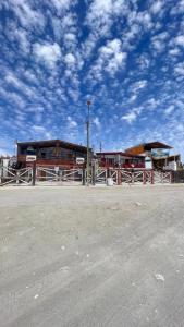 a building with a fence and a blue sky with clouds at CABAÑA VIP in Caldera