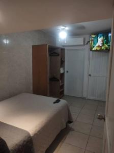 a bedroom with a bed and a tv on the wall at Hospedaje con Jacqueline in Boca del Río