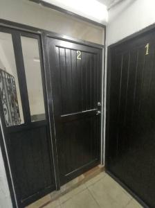 a room with two black doors in a building at Hospedaje con Jacqueline in Boca del Río