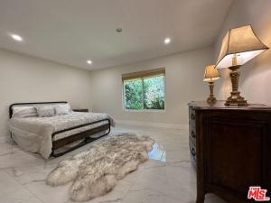 a bedroom with a bed and a table with a lamp at Lux Villa Ocean View Pool &Spa in Malibu