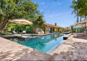 - une piscine avec un parasol et une maison dans l'établissement Lux Villa Ocean View Pool &Spa, à Malibu
