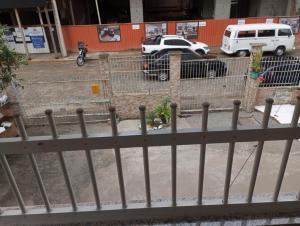 a fence with cars parked in a parking lot at Casas de Aluguel da Lulu in Itapema