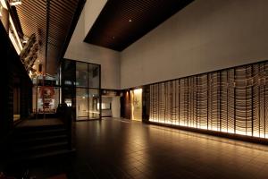 a hallway of a building with a wall filled with wood panels at Candeo Hotels Osaka Shinsaibashi in Osaka
