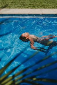 een jonge jongen die zwemt in een zwembad bij Gorilla Hostel in Mendoza