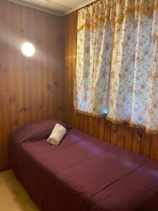 um quarto com 2 camas e uma janela em Hostal Pelluco em Llanquihue