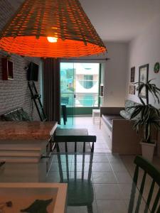 una lámpara de araña naranja colgada en una sala de estar en Residencial Ilha Bela, en Bombinhas