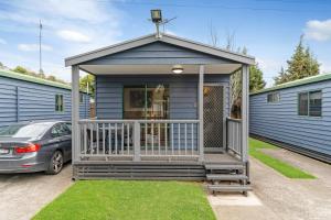 a blue tiny house with a porch and a car at Tasman Holiday Parks - Geelong in Geelong