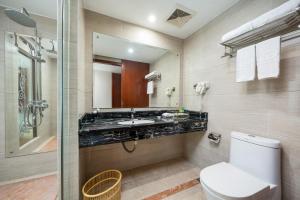 a bathroom with a sink and a toilet and a mirror at Honglilai Hotel in Bao'an
